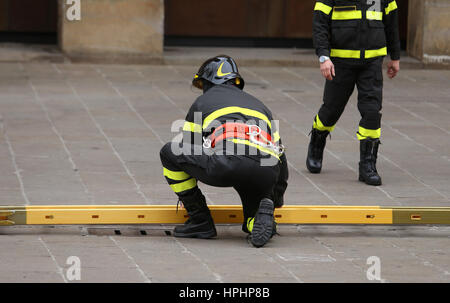 De nombreux pompiers pendant les opérations de secours avec une grande échelle en bois Banque D'Images