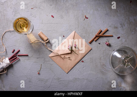 Verre de vin, enveloppe et aroma sticks sur fond de béton gris. Mariage ou saint-valentin concept. Lettre d'amour ou stylizatio message romantique Banque D'Images