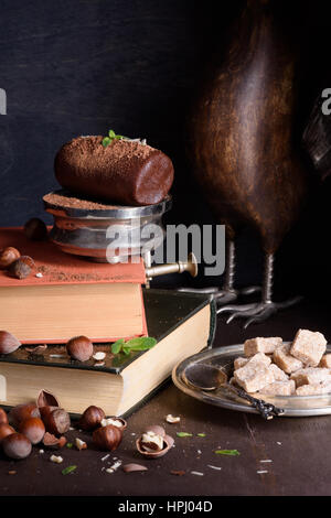 Truffe au chocolat dessert, noisette, pâte avec la poudre de cacao, de menthe et de sucre brun. Table en bois rustique, des livres anciens. Banque D'Images