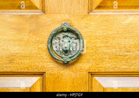 Heurtoir laiton original en forme de tête de lion, portes en bois naturel Banque D'Images