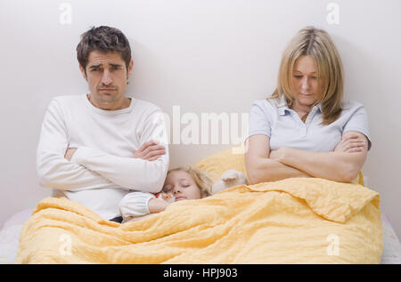 Parution du modèle , Tochter schlaeft zwischen den Eltern im Ehebett - fille dormir entre les parents au lit Banque D'Images
