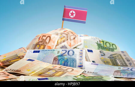 Le drapeau national de la Corée du Nord bloque dans une pile de billets européens.(série) Banque D'Images
