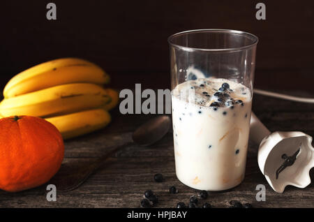 Lait frappé aux bananes smoothie de cuisson et les bleuets en immersion stick blender Banque D'Images