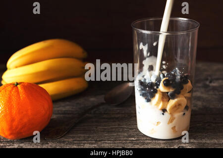 Faire un milkshake à la banane smoothie, bluberries et lait Banque D'Images