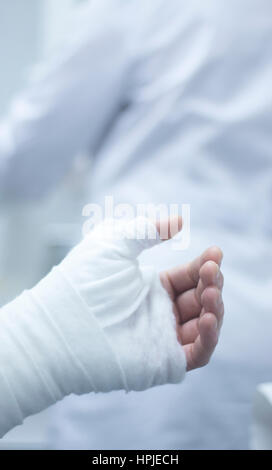 Médecin l'application d'un plâtre et des pansements à l'avant-bras et du poignet du patient afin d'immobiliser une fracture après une blessure. Banque D'Images