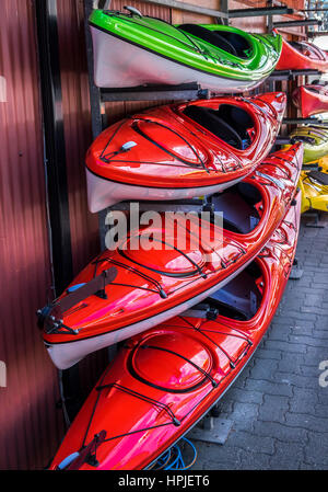 Kayaks colorés accrocher au mur rack monté à l'extérieur d'un bâtiment prêt à la vente. Banque D'Images