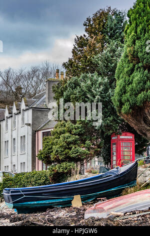 Bateaux et téléphone fort sur le quai à Portree Harbour de la plage, à la recherche à la ville. Banque D'Images