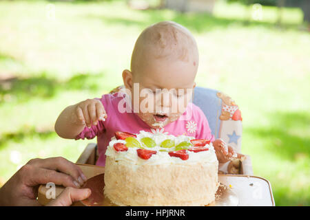 Enfant qui célèbre une année anniversaire célébration avec un gâteau aux fruits. Banque D'Images