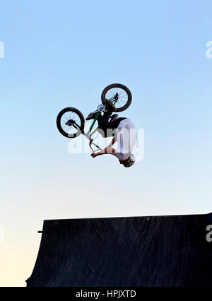 Une personne faisant un saut périlleux arrière sur une rampe de saut en vélo sur un vélo BMX Banque D'Images