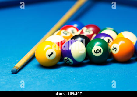 Boules de billard et pool cue sur le tissu bleu tableau Banque D'Images