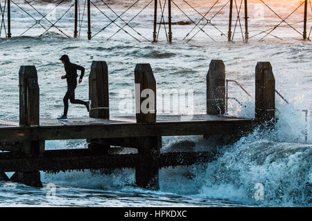 Pays de Galles Aberystwyth UK, le jeudi 23 Feb 2017 UK Weather : adolescents sur la jetée à Aberystwyth jouant un jeu risqué d'esquiver les vagues au lendemain de tempête Doris a été le quatrième ouragan de l'hiver, et a été classé comme un 'bombe météorologique cyclogénèse explosive (des) par le Met Office Crédit photo : Keith morris/Alamy Live News Banque D'Images