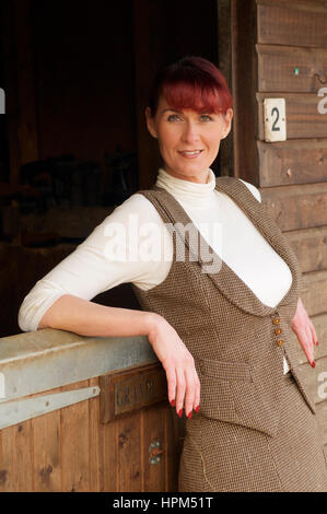 Belle femme en costume de tweed garde-chasse à la stabilité Banque D'Images