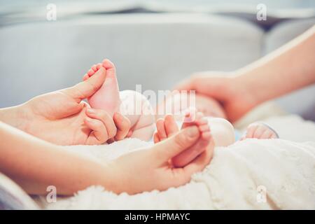 Touche de l'amour des parents. Couple caresse leur petit bébé dans le lit. Banque D'Images