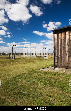 Bâtiment dortoir et de fil barbelé clôture électrique à Auschwitz II-Birkenau ancien camp de concentration Nazi, Auschwitz-Birkenau, en Pologne, en Europe de l'Est Banque D'Images