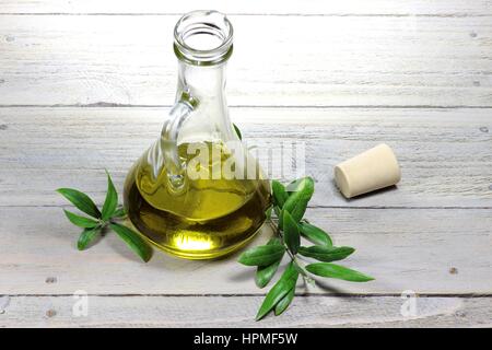 Huile d'olive vierge en une carafe en verre sur fond de bois Banque D'Images