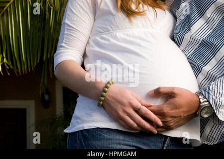Mari embraceing le ventre de sa femme enceinte. Banque D'Images