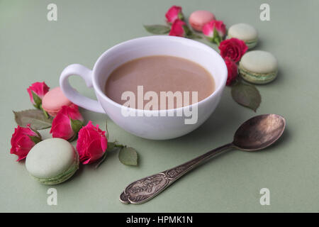 Les macarons, café et rose sur fond vert. Vue d'en haut. Mise à plat Banque D'Images