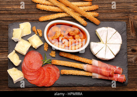 Set apéritif avec du fromage et les crevettes sur planche de bois rustique Banque D'Images