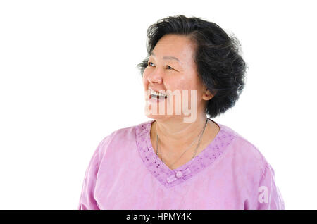 Portrait of Asian senior adult woman smiling and looking at côté, isolé sur fond blanc. Banque D'Images