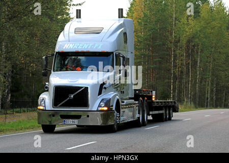 JAMSA, FINLANDE - septembre 1, 2016 : White Volvo VNL 64T 670 année 2004 remorque à plate-forme surbaissée semi se déplace le long de route sur soirée d'automne. Banque D'Images