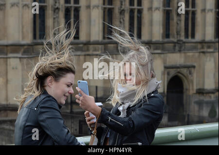 Les femmes tentent de prendre un "70623" sur le pont de Westminster, Londres, que les vols ont été annulés et les banlieusards ont été avertis qu'ils connu des retards après la tempête Doris atteint près de 90mph sur sa façon de battre la Grande-Bretagne. Banque D'Images