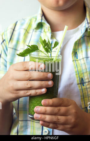 Enfant (garçon) sain potable smoothie de légumes verts - manger sain, végétaliens, végétariens, produits alimentaires et boissons biologiques concept Banque D'Images