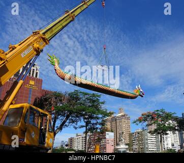 KAOHSIUNG, TAIWAN -- 27 MAI 2016 : Une grue abaisse un dragon boat sur le fleuve Amour en préparation de la Dragon Boat Festival. Banque D'Images