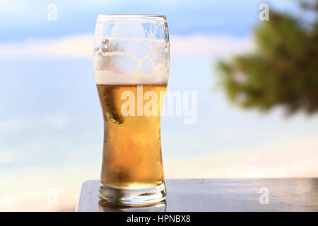 Close-up of light beer glass sur fond de mer Banque D'Images