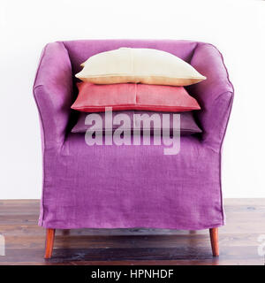 Une pile de coussins sur un fauteuil mauve. Banque D'Images