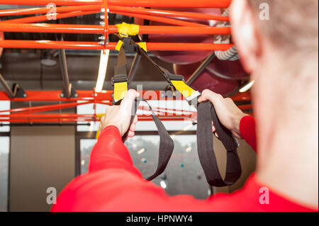 Barbu frisé blanc sporty man exercising with fitness les attaches en salle de sport Banque D'Images