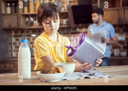 Little Boy holding boules au chocolat pour le petit déjeuner Banque D'Images