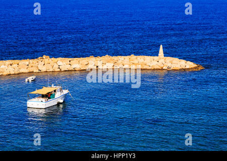 Voile et pêcheur dans le port d'Agios Georgios, Paphos, Chypre. Banque D'Images