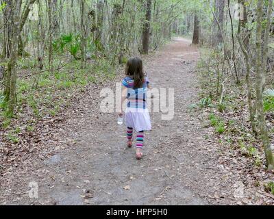 Jeune fille avec une bouteille d'eau de la randonnée à travers les bois, Gainesville, Floride, USA Banque D'Images