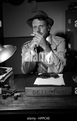 Certains fumeurs détective à 24 en trench coat, 1950 film noir style. Banque D'Images