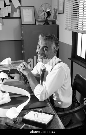 Smiling comptable professionnel travaillant à 24, 1950 Bureau de style. Banque D'Images