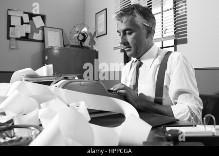 Comptable professionnel travaillant avec l'ajout de bande dans la machine de bureau vintage. Banque D'Images