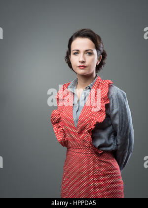 Vintage femme séduisante dans apron posing and looking at camera Banque D'Images