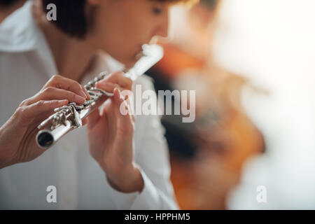 Les femmes professionnelles flute player jouer avec l'orchestre symphonique de la musique classique, personne méconnaissable Banque D'Images