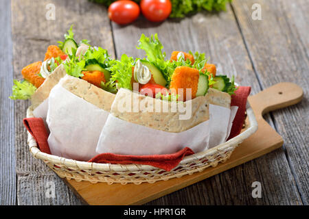 Sandwich Pita farci de bâtonnets de poisson croustillant, salade et sauce rémoulade Banque D'Images