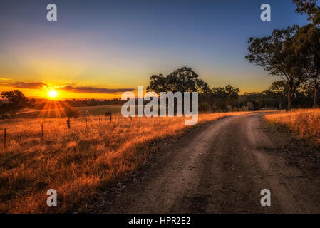 Paysage de campagne pittoresque avec rural route de terre au coucher du soleil en Australie Banque D'Images