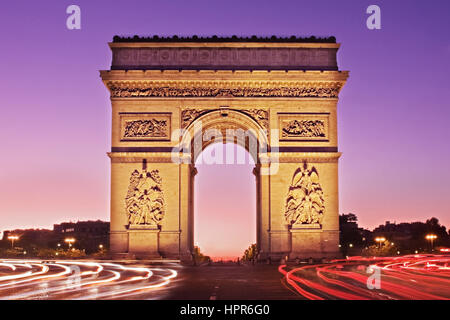 L'aube d'une vue sur l'Arc de Triomphe de l'Avenue de la Grande Armée. La lumière des sentiers mènent à la circulation et autour du monument historique. Banque D'Images