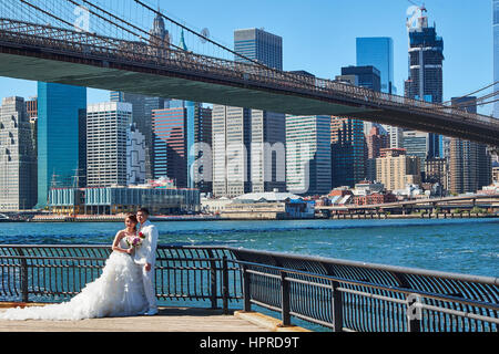 DUMBO, NEW YORK - 25 septembre 2016 : Wedding couple debout sur une jetée à Dumbo à Brooklyn, avec pont de Brooklyn à l'arrière-plan Banque D'Images