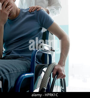 Femme médecin triste consolation man sitting in wheelchair Banque D'Images
