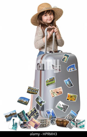 Petite fille aux cheveux longs avec chapeau de paille est debout et s'appuyant sur une valise. Photos des sites touristiques de New York vole autour de la valise. Tout est Banque D'Images