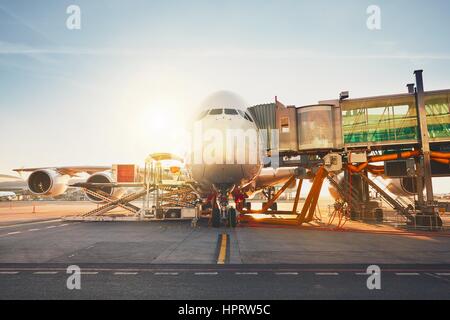 Aéroport très fréquenté en journée ensoleillée. Préparation de l'énorme avion avant le vol. Banque D'Images