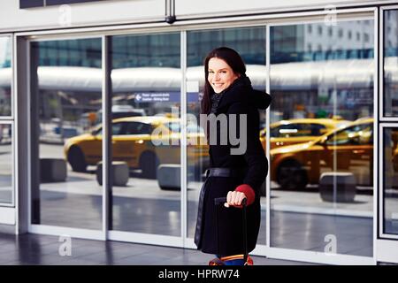 Femme réussie en face de l'aérogare à l'aéroport. Banque D'Images