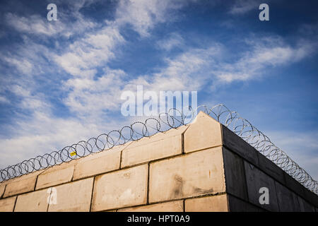 Un mur recouvert de bobines de fil de fer barbelé de protection Banque D'Images