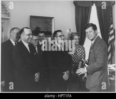 Le personnel des Archives nationales, y compris l'archiviste des États-Unis, M. Grover (troisième à partir de la gauche) et l'administrateur adjoint de l'Administration des services généraux, Bernard Boutinn, présentent les premiers volumes des documents publics des Présidents des États-Unis, John F. Kennedy, au Président Kennedy (à l'extrême droite), Washington, DC, 1962. Banque D'Images