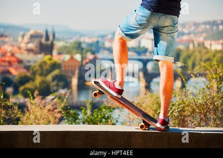 Jeune skateur professionnel est à cheval sur la planche à roulettes dans la ville. Prague, République tchèque. Banque D'Images