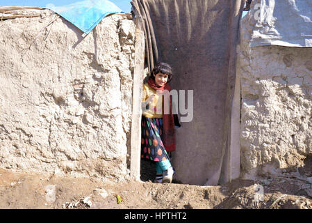 Kaboul, Afghanistan. Feb 23, 2017. Une jeune fille se tient devant sa maison dans le nord de l'agglomération de Kaboul, Afghanistan, le 23 février 2017. L'hiver a presque recouvert d'Afghanistan, qui affectent la vie des familles pauvres, en particulier ceux qui n'ont pas d'équipement, réchauffement de l'eau propre ou assez de nourriture pour faire face à la saison froide. Dans le nord de l'agglomération de Kaboul, beaucoup vivent encore dans des bâtiments de boue, et n'ont pas d'argent pour acheter du bois pour le feu. Credit : Dai il/Xinhua/Alamy Live News Banque D'Images